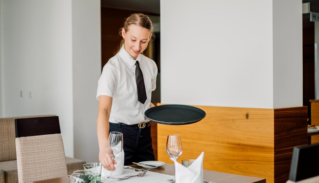 Restaurantfachfrau deckt den Tisch im Restaurant des 4*S Hotels ein | © Spa Resort Geinberg / Chris Perkles